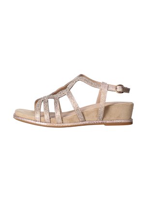 Sandalia de cuña beige con parte superior de varias tiras brillantes y correa ajustable en el tobillo con hebilla dorada, suela plana y soporte trasero cerrado.