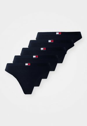 Cinq paires de tangas en coton noir avec ceintures élastiques, présentant un petit logo rectangulaire en rouge, blanc et bleu à l'avant.