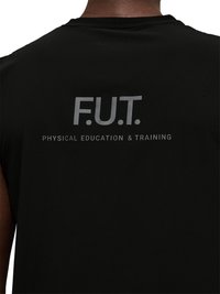 Vue arrière d'une personne portant un t-shirt noir avec l'inscription "F.U.T. Physical Education & Training" imprimée en gris sur le haut du dos.