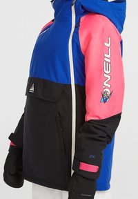 Veste d'hiver pour enfants O'Neill à blocs de couleurs bleu, rose et noir, fermeture éclair frontale et logo sur la manche droite.