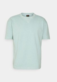 Světlá máta zelená tričko s krátkým rukávem, kulatý výstřih, měkká textura, obsahuje malou logovou nášivku na límci, uvolněný střih.