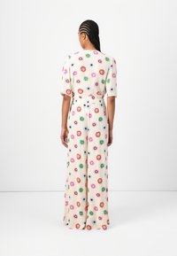 Floral maxi dress with short sleeves, featuring multicolored patterns on a cream background, elastic waist, and floor-length design.