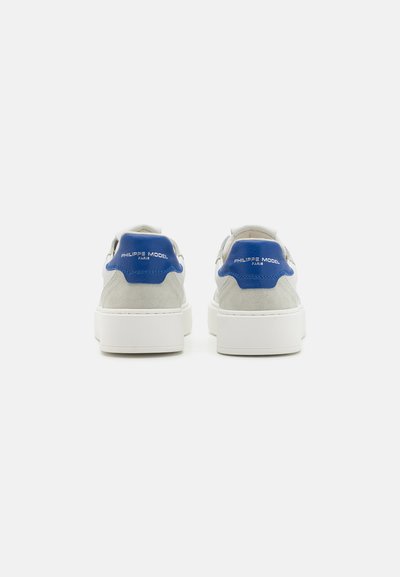 Baskets pour hommes en suède gris avec des accents bleus. Semelle en caoutchouc blanc épais, texture lisse, détails du logo sur le talon. Design à bout rond.