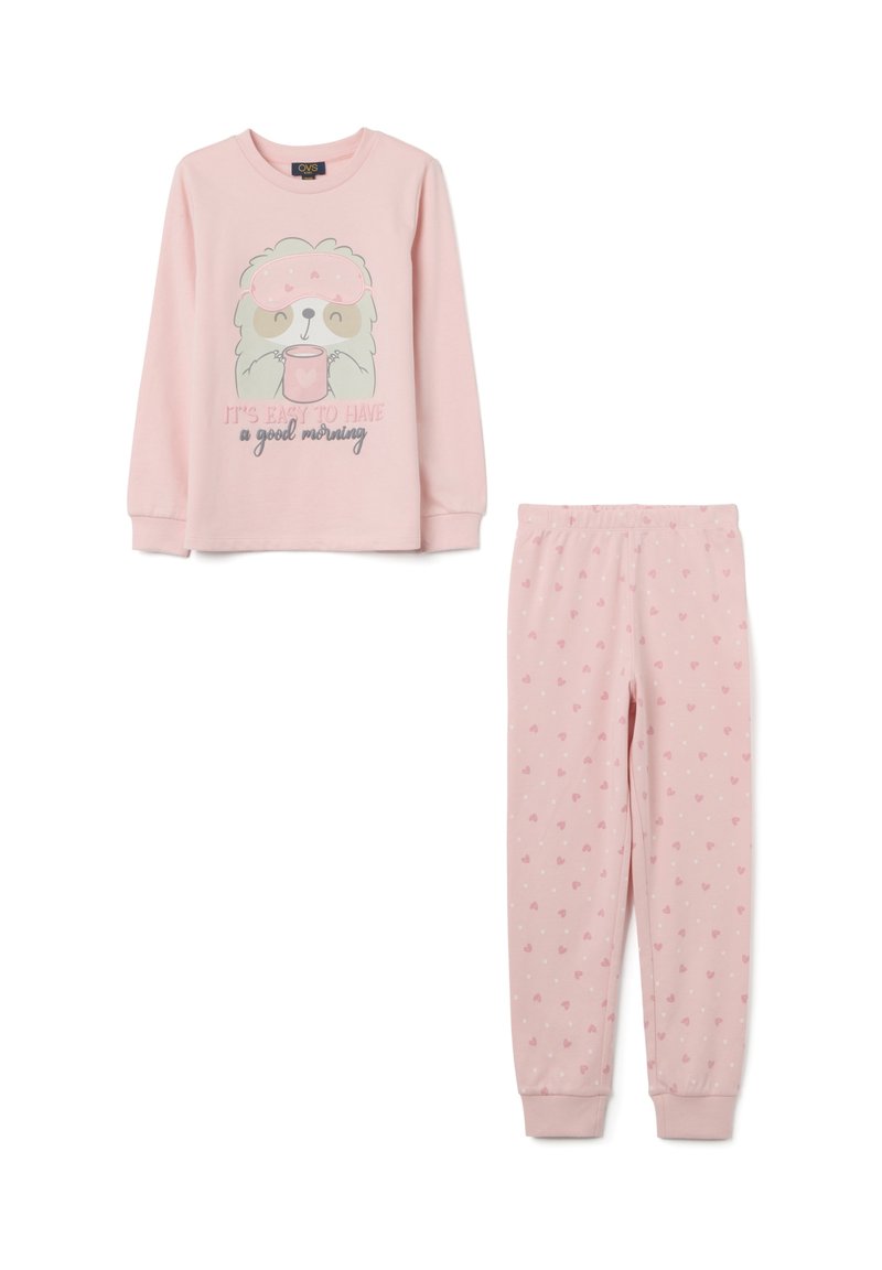 El conjunto de pijama rosa incluye una camiseta de manga larga con un personaje de dibujos animados y texto, y pantalones a juego con pequeños patrones de corazones. Tela suave.