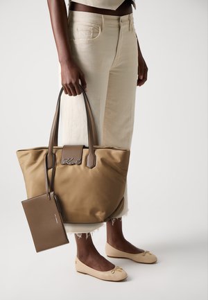 Brun nylon toteveske med korte håndtak, med et metallisk logo og en matchende glidelåslomme. Beige ballettsko med bue-detalj.