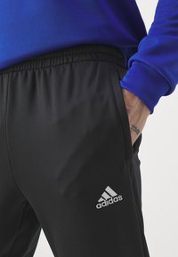 adidas Sportswear SPORTSWEAR HOODED TRACKSUIT SET - Tuta - semi lucid blue/black