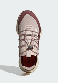 Chaussure de sport en rose pâle et bordeaux. Tige en mesh avec des accents texturés, système de laçage intégré et semelle rembourrée.
