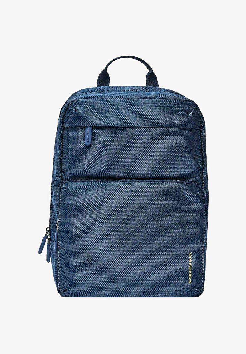 Sac à dos bleu marine avec une surface texturée et perforée, deux compartiments zippés et une poignée sur le dessus. Présente un détail de logo doré sur le côté.