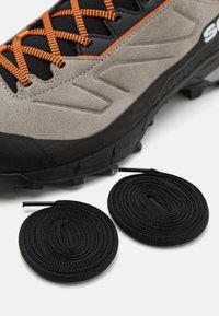 Szare buty trekkingowe z czarnymi i pomarańczowymi akcentami, z teksturowanej zamszowej cholewki oraz solidną podeszwą, w towarzystwie dwóch okrągłych czarnych sznurowadeł.