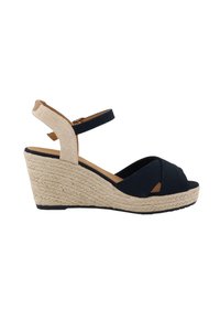 Sandale compensée marine avec un orteil ouvert et un design à brides croisées. Dispose d'un talon enroulé de jute et d'une bride de cheville en tissu texturé.