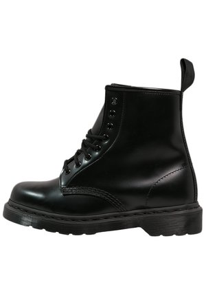 Schwarzer Leder-Schnürstiefel mit dicker Gummisohle und Lasche an der Ferse, seitlich dargestellt.