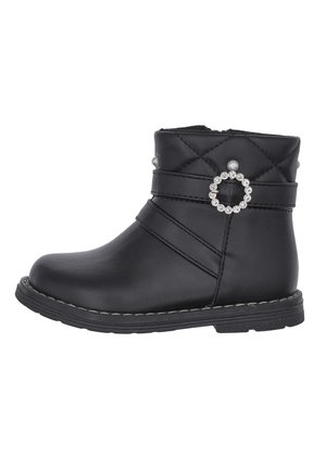 Bottine noire à cheville avec dessus matelassé, boucle ronde décorative en strass, accents de perles et semelle cousue sur fond blanc.