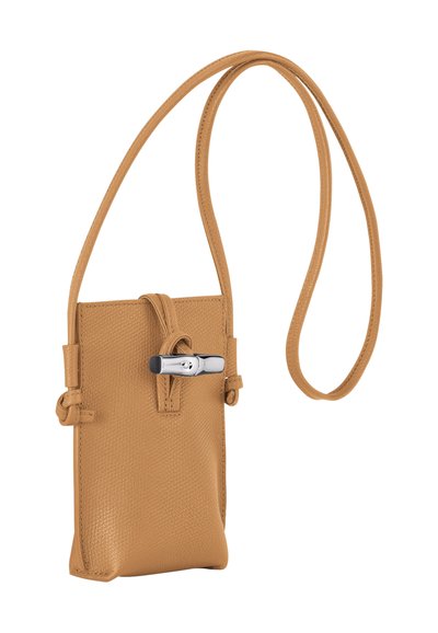 Tan leather crossbody bag with a textured finish, knotted strap, and a silver hardware closure. Compact rectangular shape.