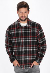 Svart och röd rutiga flanelljacka med grå detaljer, med knapplist fram och spridd krage. Mjuk textur, långa ärmar och sidofickor.