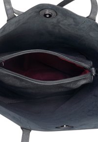 Zwarte leren tote bag met een gladde buitenkant, voorzien van een bordeauxrood binnenwerk en een ritsvak. Sluit met een drukknoop.