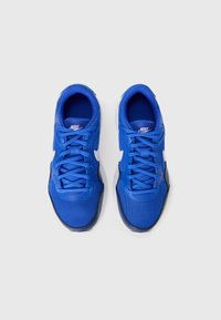 Plave Nike tenisice od mrežastih i sintetičkih materijala, s ravnim vezicama, bijelim logotipom i kontrastnom tamnom petom.