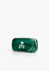 Pochette rectangulaire transparente verte avec un dessin blanc de tête de mort et os croisés, et une fermeture éclair blanche sur un fond blanc.