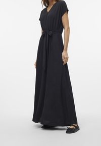 Svart maxiklänning med V-ringning, korta ärmar och knytmidja. Tillverkad av textil med struktur, har den en flödande design och sidöppningar.