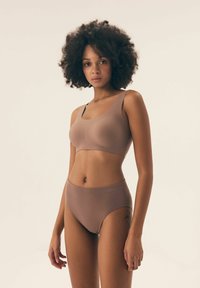 Brązowy zestaw składający się z bezszwowego biustonosza i majtek z wysokim stanem, gładka tekstura, miękka tkanina, minimalistyczny design, z szerokimi ramiączkami i niewidocznymi szwami.