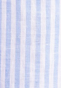 Tessuto a righe blu e bianche con una trama strutturata, caratterizzato da righe larghe e strette alternate, principalmente realizzato in cotone o lino.