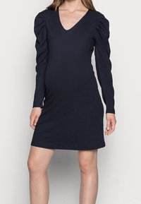Marinblå långärmad klänning med V-ringning, texturerad tyg och puffärmar, med en figurnära silhuett och längd ovanför knäet.