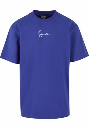 Bomull T-shirt i livlig lila med rund hals, korta ärmar och broderad vit signaturdetalj på framsidan.