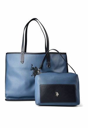 Bolso tote de cuero azul con asas negras y un neceser azul a juego más pequeño con bolsillo delantero negro y logotipo de caballo plateado.