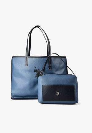 Bolso tote de cuero azul con asas negras y un neceser azul a juego más pequeño con bolsillo delantero negro y logotipo de caballo plateado.