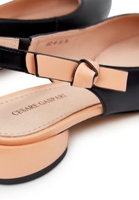 Scarpa slingback nera in pelle con cinturino in pelle nuda, tacco a blocco e soletta imbottita con bordo cucito e stampa del logo del marchio.