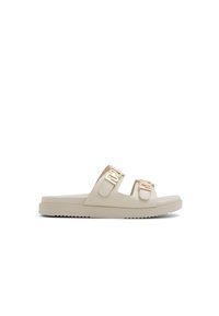 Sandales à glissière beige clair avec deux boucles en ton or, finition lisse et texturée, et une semelle en caoutchouc plate présentant un motif en zigzag.