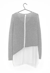 Maglione grigio a maglia con parte inferiore in chiffon bianco a strati, caratterizzato da un orlo arrotondato e una chiusura a bottone sul retro. Finitura testurizzata su tutta la superficie.