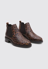Botas ankle de estampado de leopardo marrón con paneles elásticos laterales y un tacón bajo, que presentan una textura suave y un diseño de punta redonda.