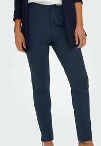 Marinblå skräddarsydda byxor med slim fit, som har en framdragkedja, två bakfickor och en slät, texturerad yta.