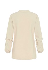 Camicia beige a maniche lunghe con collo a revers. Presenta polsini arricciati e un tessuto morbido e testurizzato. Design semplice e privo di decorazioni.