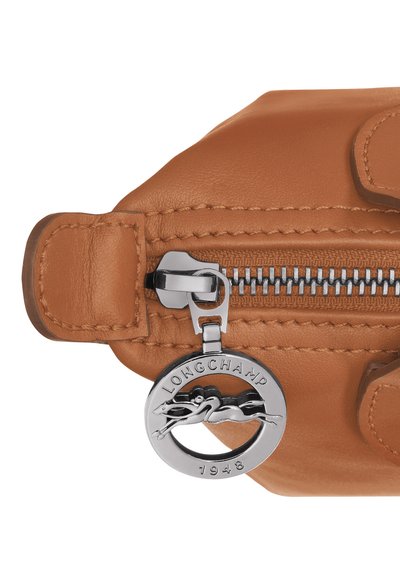 Brown leather accessory with a silver zipper and round branded charm depicting a leaping horse, featuring detailed stitching and smooth texture.