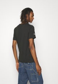 Puma LOGO TEE - Triko s potiskem - puma black