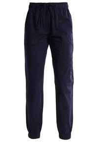 Pantalons de jogging bleu marine en coton, dotés d'une taille élastique avec cordon de serrage, de poches latérales et de poignets élastiques aux chevilles.