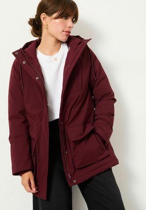 Burgundy puffer jacket with a hood, featuring zip and snap closures, front pockets, and a slightly oversized fit. Smooth fabric texture.