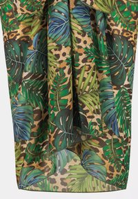 Wzorzysta tkanina z zielonymi liśćmi i nadrukiem lamparta na jasnobeżowym tle, prezentująca żywe kolory i skomplikowane detale.