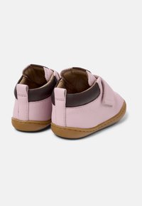Zapatos de piel rosa para toddler con acentos marrón oscuro, forma redondeada y cierres de Velcro. Diseñados con una suela flexible y costuras resistentes.