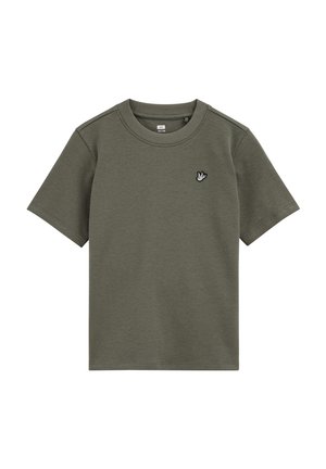 T-shirt vert olive à manches courtes, col rond, avec un petit emblème d'oiseau blanc sur la poitrine gauche.