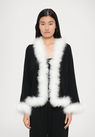 Sort jakke med lange ærmer, med hvidt faux fur-bånd langs kraven og manchetterne. Glat stof med en afslappet pasform.