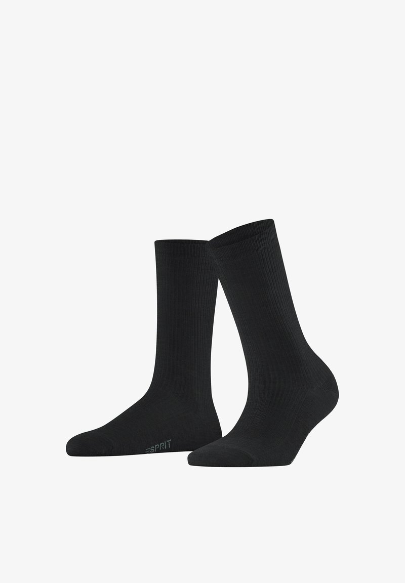 Paire de chaussettes noires unies côtelées mi-mollet avec un petit logo discret près des orteils sur fond blanc.