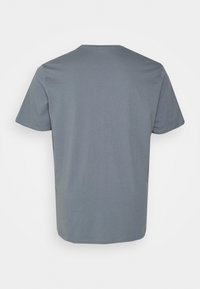 Camiseta gris de manga corta hecha de algodón, con cuello redondo y textura suave. Diseño sencillo sin patrones ni adornos.