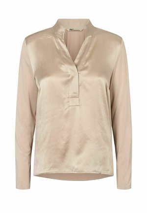 Blouse beige en tissu soyeux à manches longues avec col en V et col droit, coupe ample et tissu lisse et brillant.