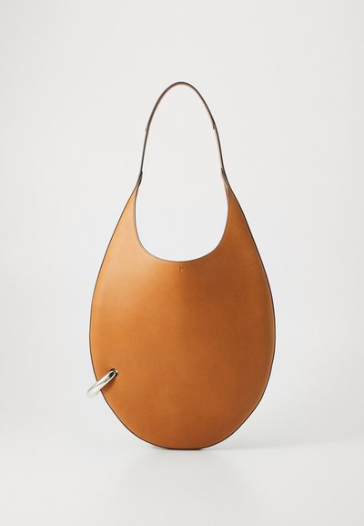 Hobo-artige Handtasche aus glattem, beige Leder, mit runder Form, einem eleganten Griff und einem silberfarbenen Ringdetail.