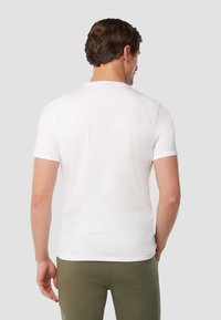 Witte katoenen t-shirt met korte mouwen, ronde hals, gladde textuur en een gestikte zoom, gedragen met olijfgroene broek. Geen zichtbare logo's of patronen.