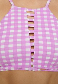 Top de biquíni em padrão quadriculado roxo e branco, com alças finas e um design com recorte central e fendas horizontais. Material suave e elástico.