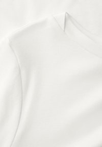 Weißer Baumwoll-T-Shirt-Stoff, glatte Textur, mit rundem Ausschnitt und dezenten Nähten, präsentiert in einer gefalteten Anordnung.