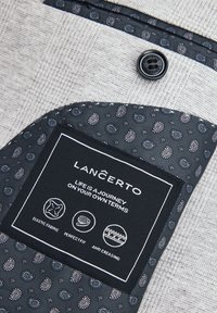 Teksturowana szara tkanina z czarną podszewką w wzory paisley. Etykieta zawiera napis "Lancerto" oraz instrukcje dotyczące pielęgnacji w białym tekście.